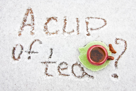 在下雪的背景上喝一杯茶