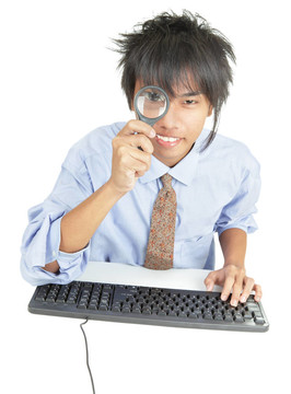 年輕的亞洲商人通過放大鏡觀察