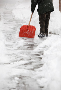 男人鏟人行道上的雪在他的房子前面的一個城市，大雪之后