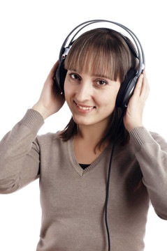 年輕迷人的微笑女孩在耳朵里聽音樂
