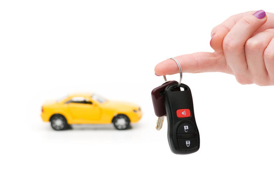 汽車鑰匙和汽車在背景上孤立的白色