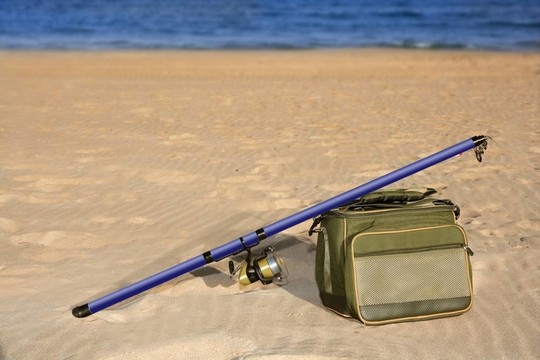 釣魚桿在沙灘激浪投釣箱