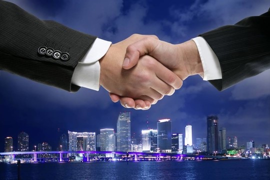 在繁華的夜miamy商人握手