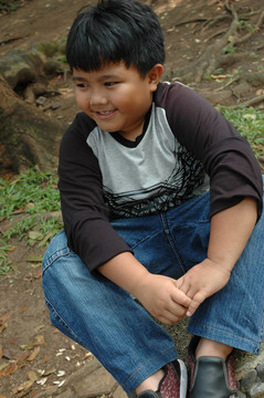 小男孩坐在公園里