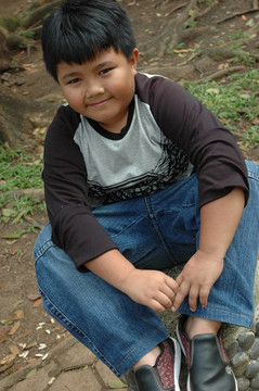 小男孩坐在公園里