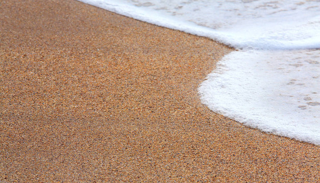 海岸沙灘上的海浪泡沫
