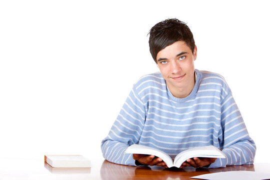 年輕快樂英俊男學(xué)生閱讀學(xué)習(xí)書