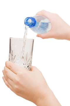 女孩把水倒在玻璃杯里