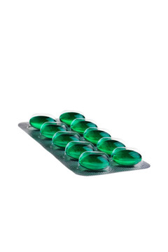 白色背景隔離銀包裝中的綠色藥片。