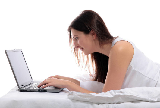 與noetbook電腦在床上的女人