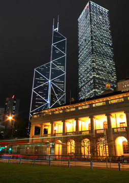 這是兩個(gè)摩天大樓建筑在香港的夜景背后的英文