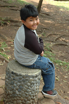 小男孩坐在公園里