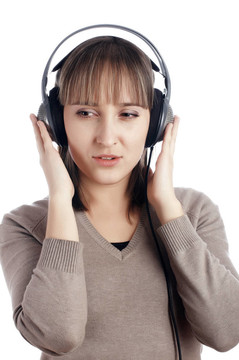 年輕迷人的微笑女孩在耳朵里聽音樂