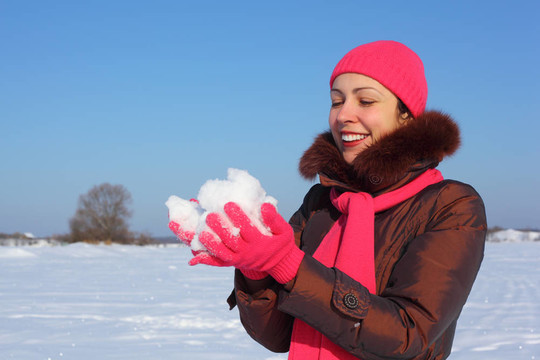 年輕的美女在戶外戶外抱著雪