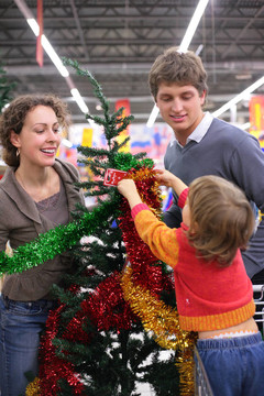 带孩子的家长买圣诞树装饰