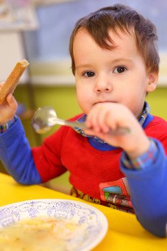 小男孩在幼兒園吃飯