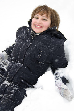 微笑的女孩躺在雪地里