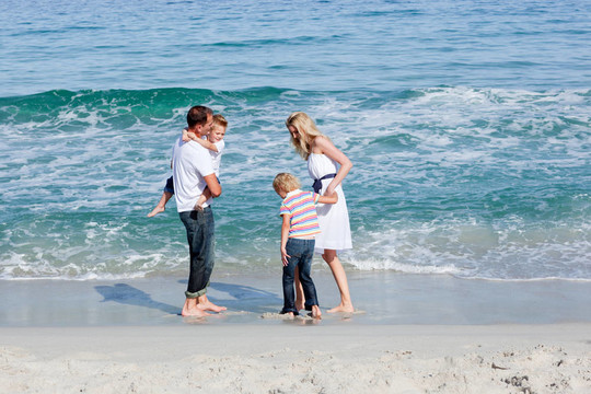 在沙滩上玩乐的幸福家庭