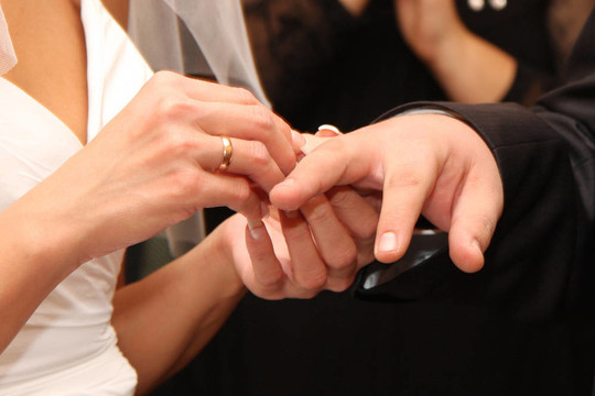 那個女人用手指向男人戴結(jié)婚戒指