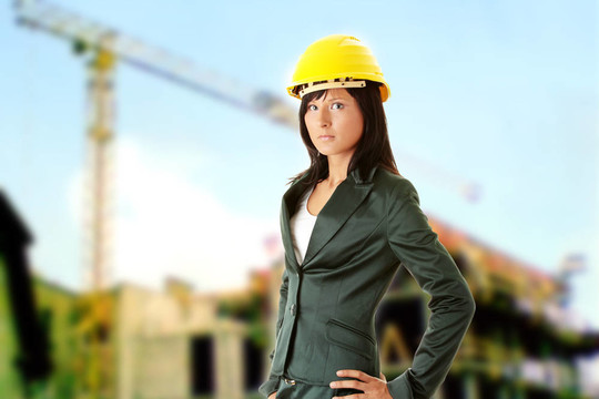 年輕的女建筑師或者建筑工人戴著黃色安全帽
