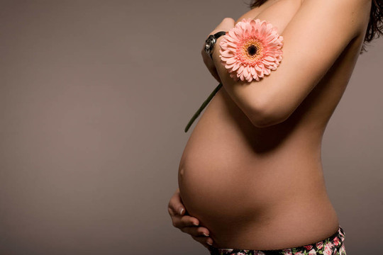 抱著花的孕婦
