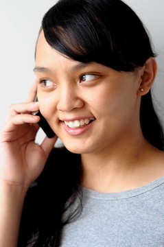 甜美的亞洲女孩在電話里交談