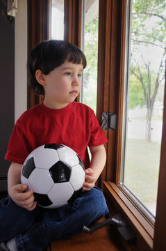 男孩想在下雨天踢足球