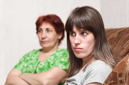 成熟的女人一個(gè)年輕的女孩和一個(gè)女兒一起在沙發(fā)上