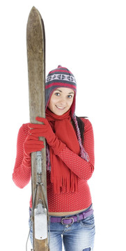 微笑的年輕女子在冬季帽持有舊木滑雪