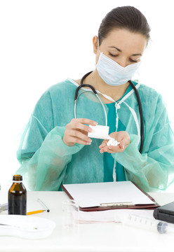 女性醫(yī)生在保護(hù)綠色制服和醫(yī)療面具與藥物在辦公室剪貼板