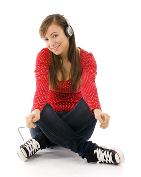 坐在地板上穿着红色衬衫的年轻女子听音乐