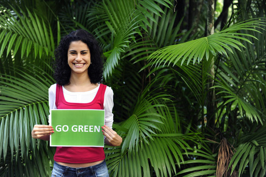 环境保护：森林中的女人拿着绿色标志