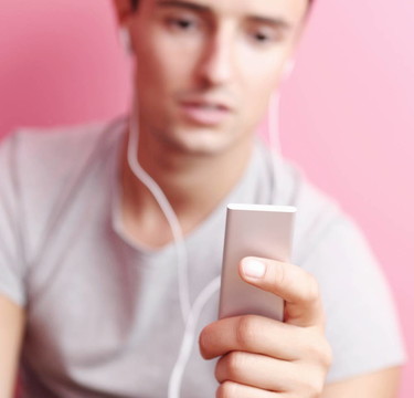 年輕英俊的男人在他的便攜式MP3播放器在自己的房間里聽音樂