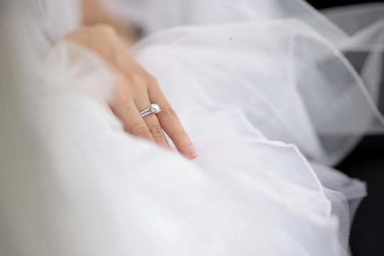 新娘的手放在結婚禮服上
