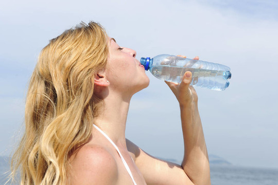 口渴的女人夏天在室外喝水