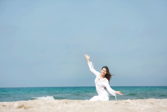 年輕快樂的女孩在海灘上冥想