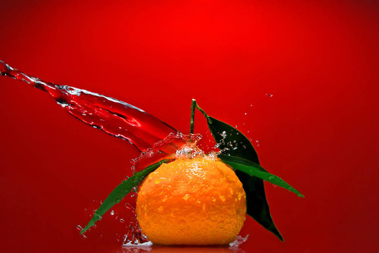 Tangerine夜店有綠色的葉子和紅色背景上潑水