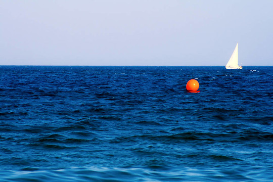 白色的帆船；藍(lán)色的海浪和天空