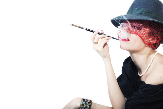 戴著面紗的年輕漂亮女人戴著帽子在燈光背景下戴面紗