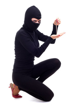 在黑色的衣服和帽子保持手鐲的女小偷