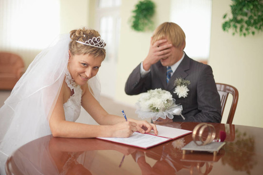 婚姻登記。新娘是快樂的。悲傷的新郎。