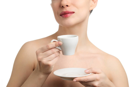 赤裸的女人喝咖啡或茶。