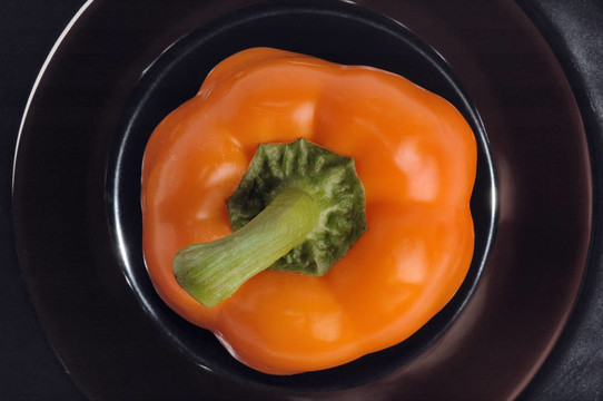 黑色盤子上的橙色的甜胡椒