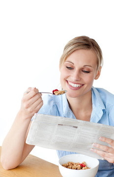 女人在看报纸时吃麦片