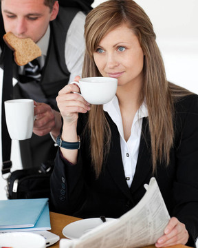 美麗的businesswomand喝咖啡而她丈夫趕緊起床