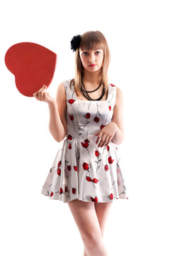 美麗的女孩穿著紅色的衣服和心在手