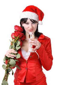 一個美麗的年輕女子的肖像在紅色的西裝和帽子的圣誕老人與紅玫瑰和香檳的白色背景