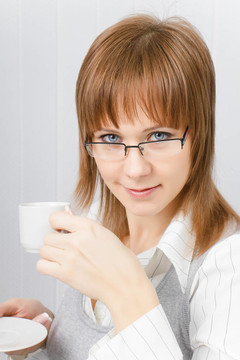 漂亮的女孩在辦公室里拿著一杯咖啡