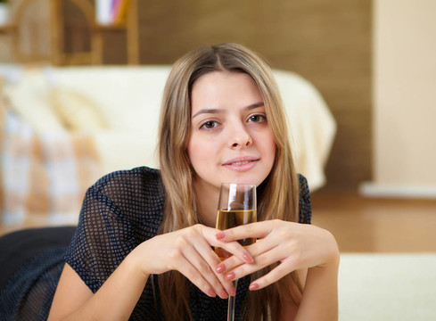 年輕女孩在家里喝香檳