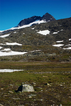 在小雪原斯堪的納維亞nordkalottleden山；一個小湖泊和藍(lán)天一些跟蹤標(biāo)記